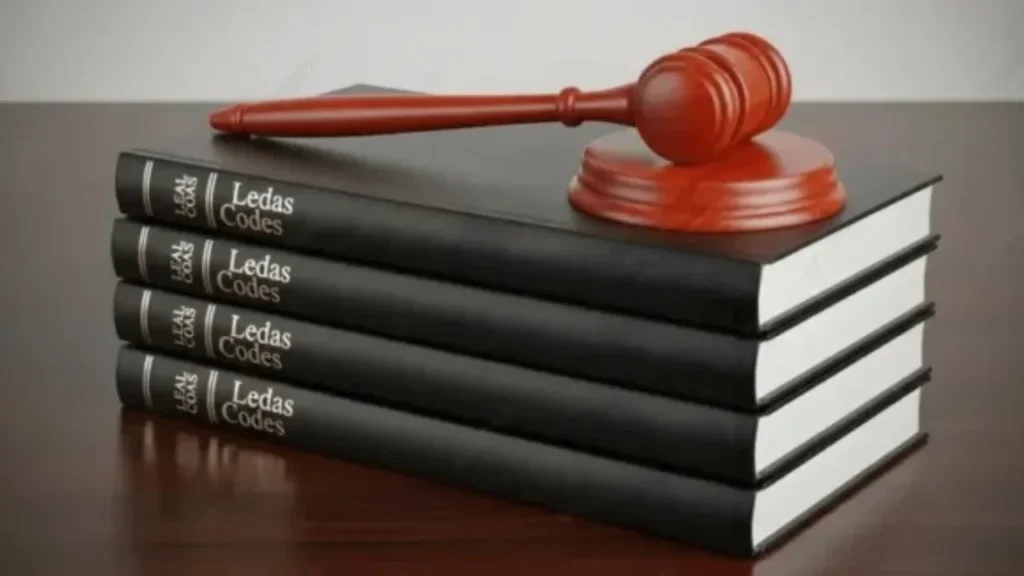 Imagem ilustrativa como livros judiciais e uma marreta de juiz em alusão as pautas sobre Gravame