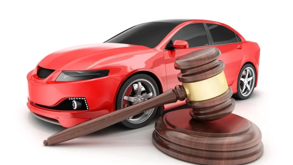 Imagem ilustrativa de um carro vermelho e um martelo de tribunal na cor madeira