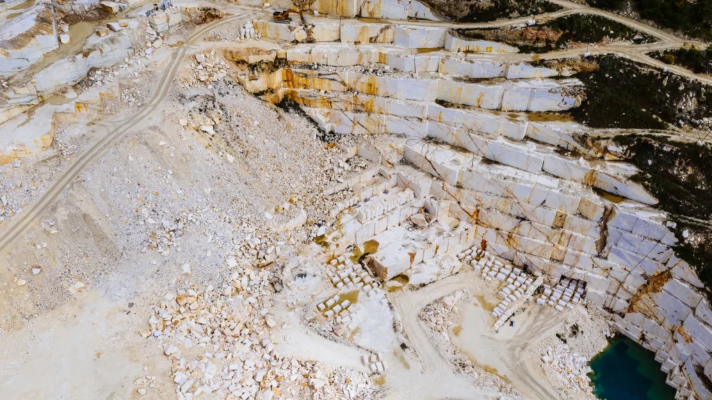 Vista aérea de pedreira de mármore mostrando bancadas escalonadas e blocos extraídos.