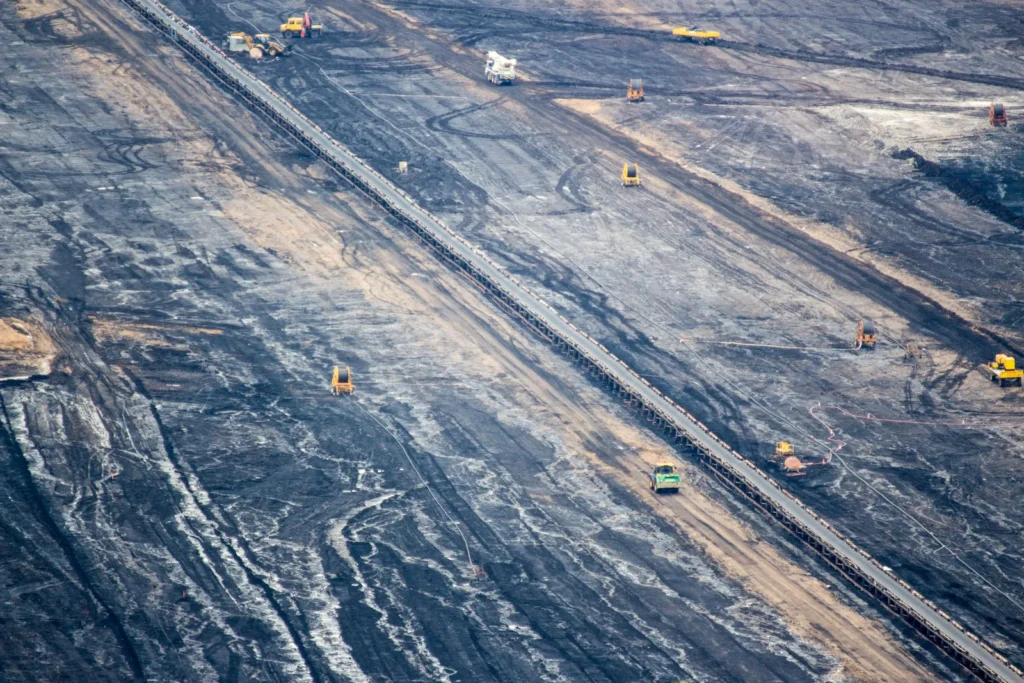 Vista aérea de mina de carvão mineral a céu aberto com esteiras e maquinário.