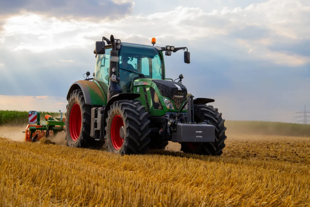 Trator moderno operando em plantação agrícola durante o entardecer