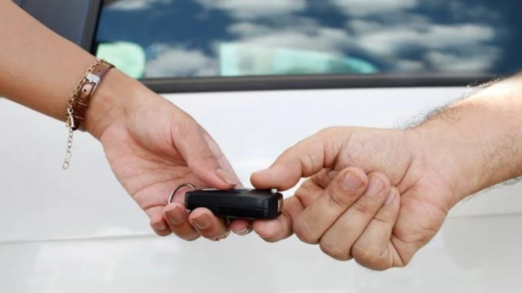 Duas pessoas segurando a chave de um carro em alusão a pauta Adeus à papelada? Transferência de veículos pelo celular ganha força em 2026