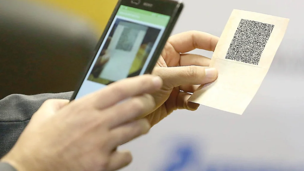 Foto de uma pessoa com um celular tentando escanear documento de Qr Code