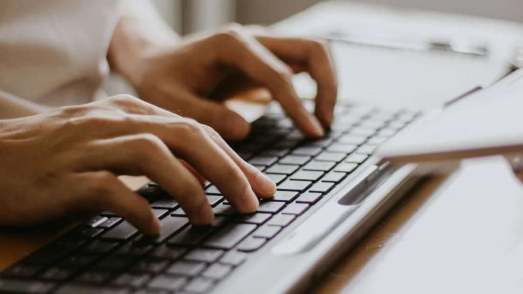 Foto de duas mãos digitando em um notebook referente a pauta "como entender uma consulta de cnpj"