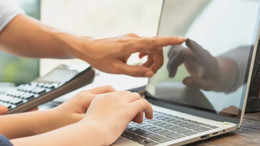 Foto de duas pessoas mexendo em um computador referente a pauta "Como saber se um CNPJ está ativo"