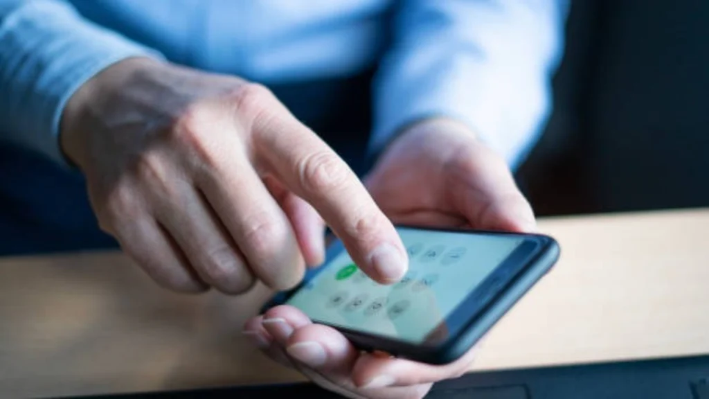 Pessoa mexendo no celular em alusão a pauta descobrir número de telefone grátis