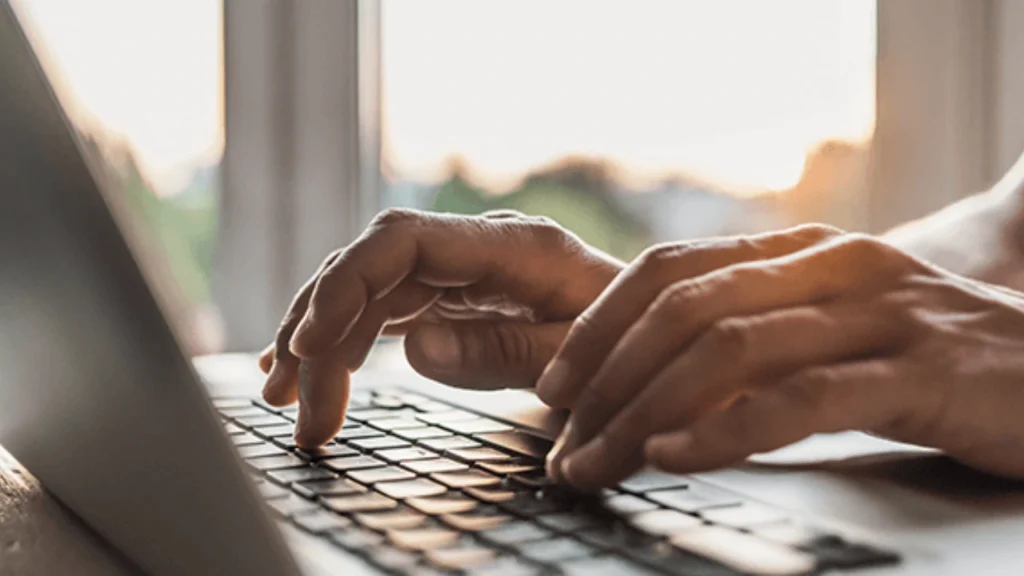Foto de duas mãos digitando em um notebook referente a pauta "O que significa CNPJ inapto"