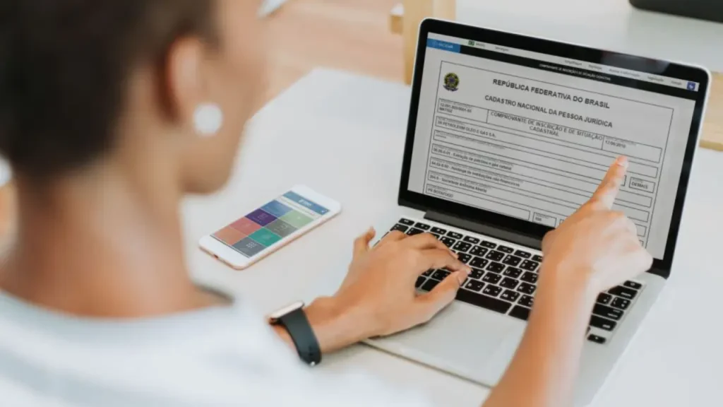 Foto de homem branco caucasiano em frente ao notebook realizando um consulta de CNPJ em alusão a pauta "Situação cadastral baixada no CNPJ: o que significa e como resolver?"
