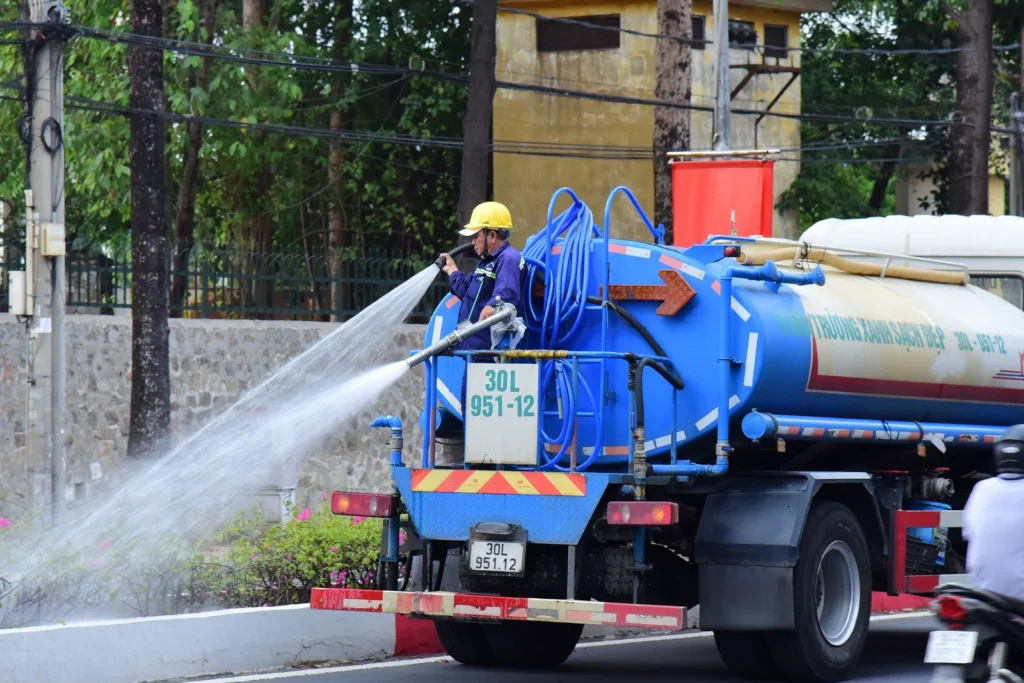Caminhão pipa realizando distribuição de água na rua