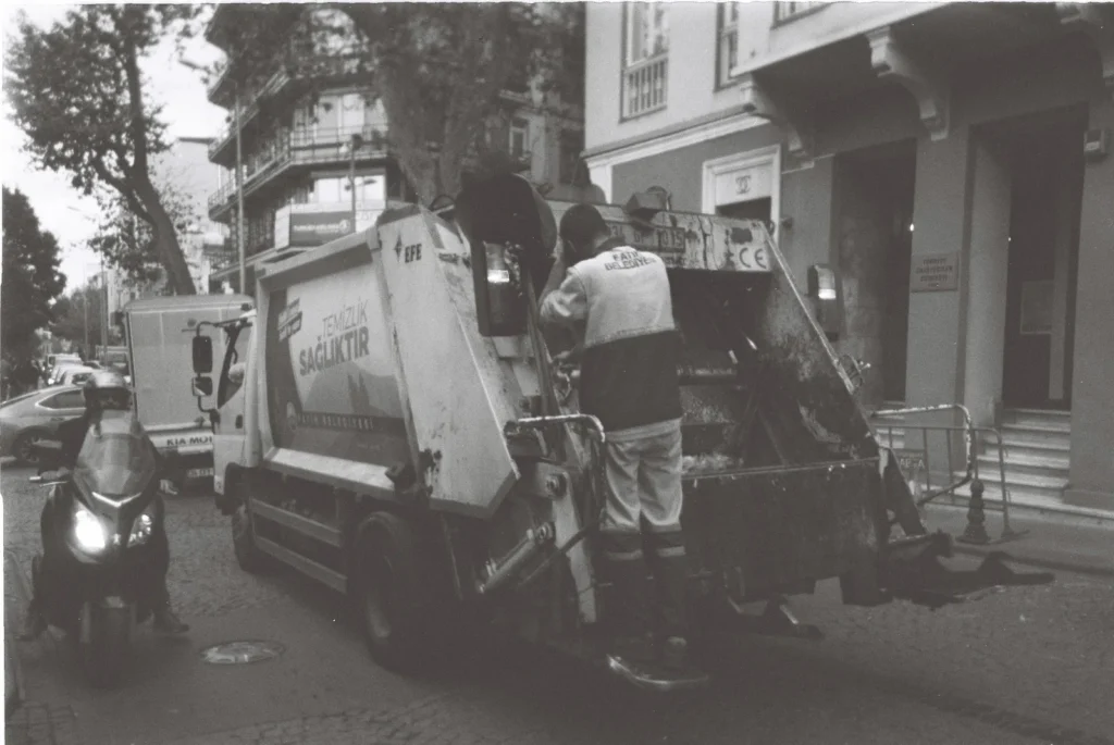 Caminhão de coleta de lixo urbano realizando serviço na rua