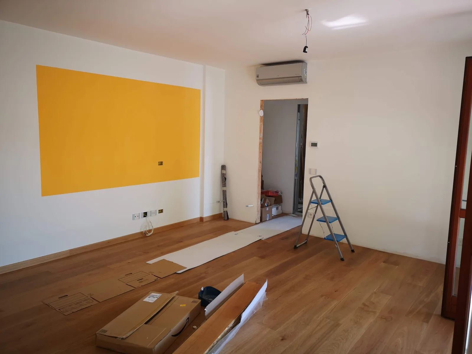 carpeteiro instalando porta de madeira em obra residencial