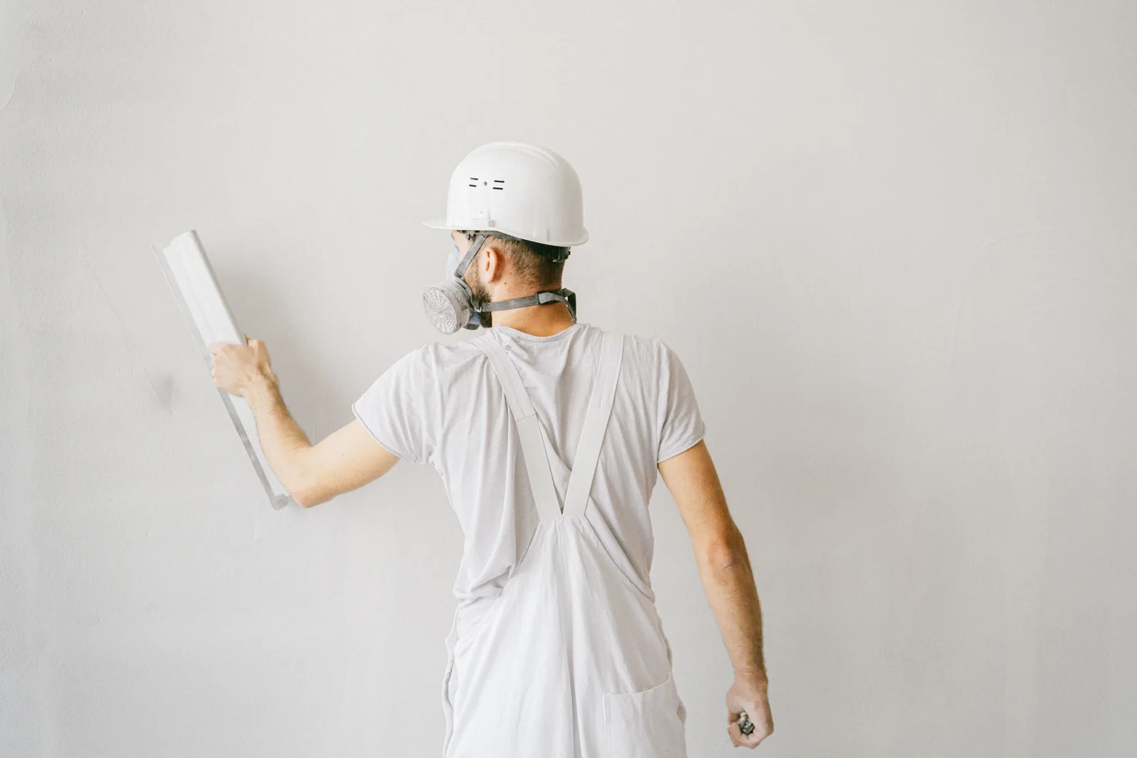 pedreiro aplicando gesso em parede de obra