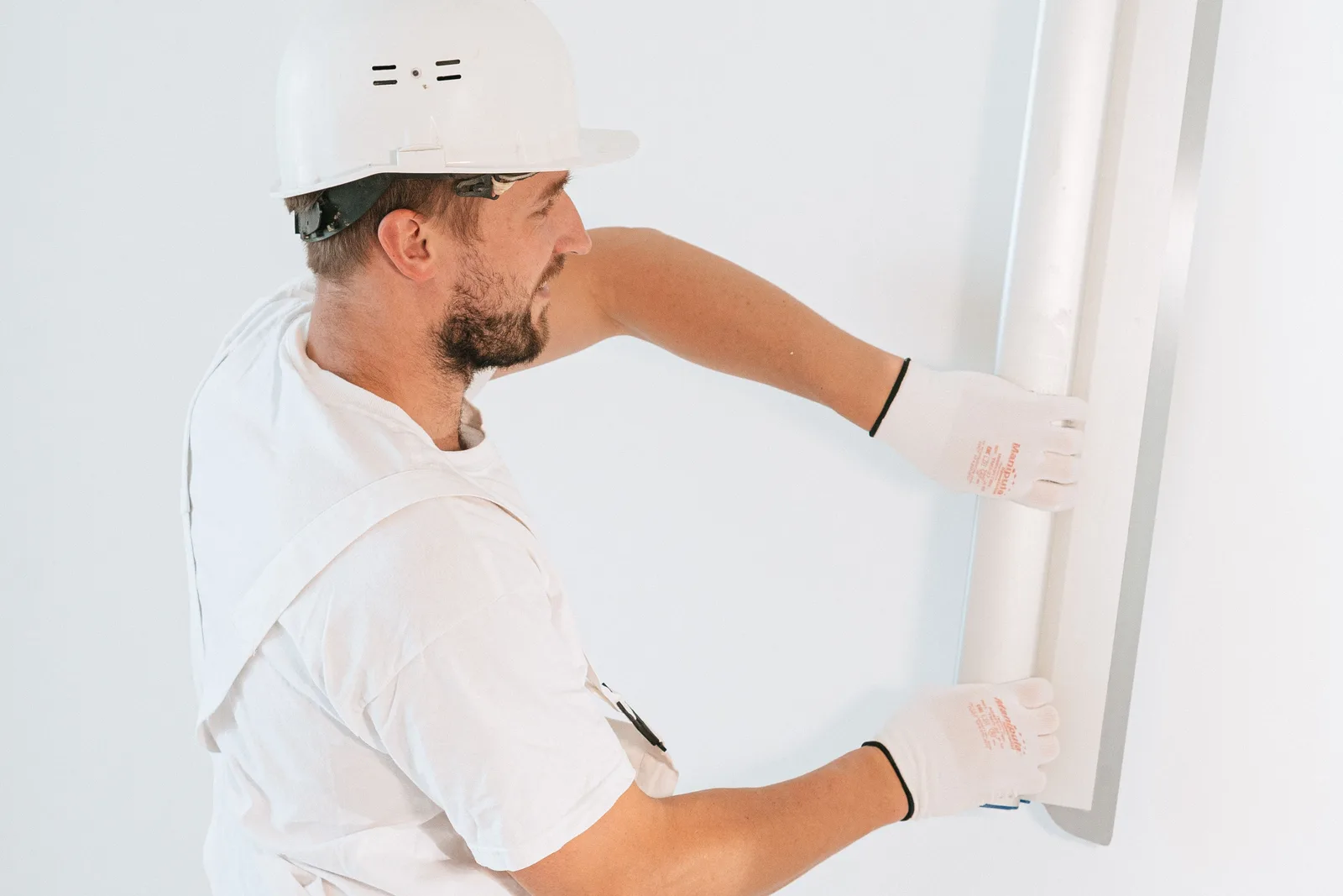 pedreiro instalando gesso em teto de obra residencial