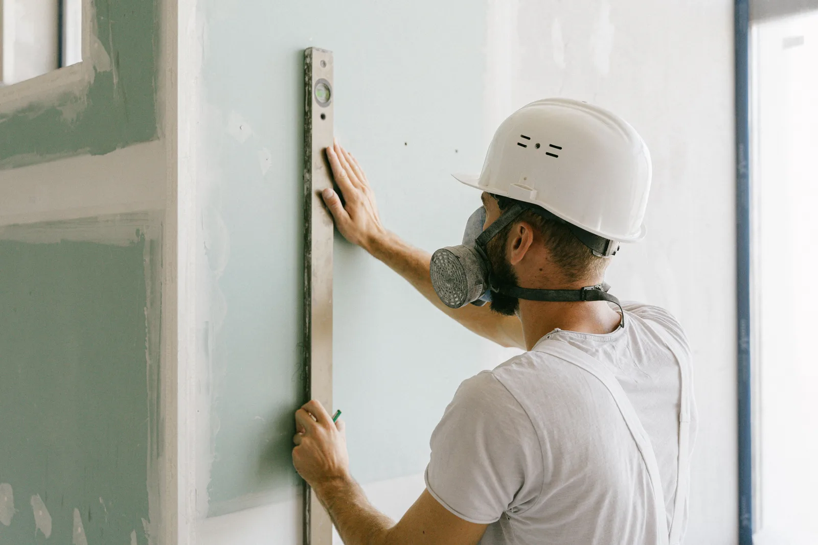 profissional aplicando gesso em parede de uma obra