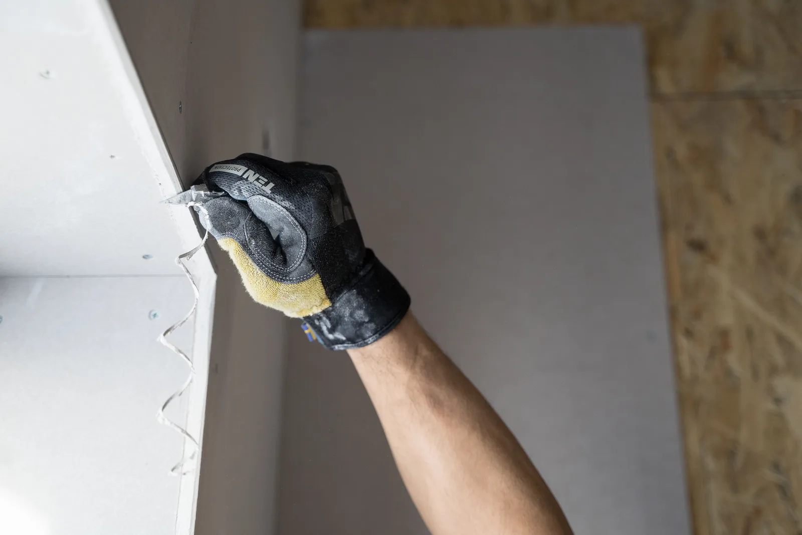 trabalhador aplicando gesso em parede de obra