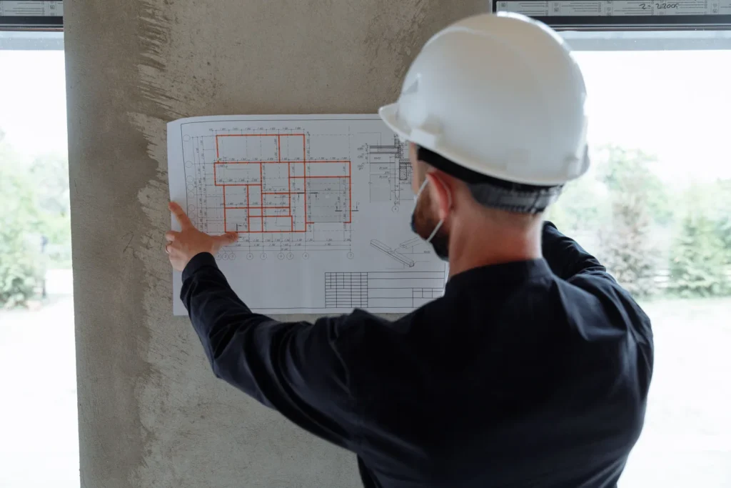 Engenheiro civil analisando planta de obra em canteiro de obras