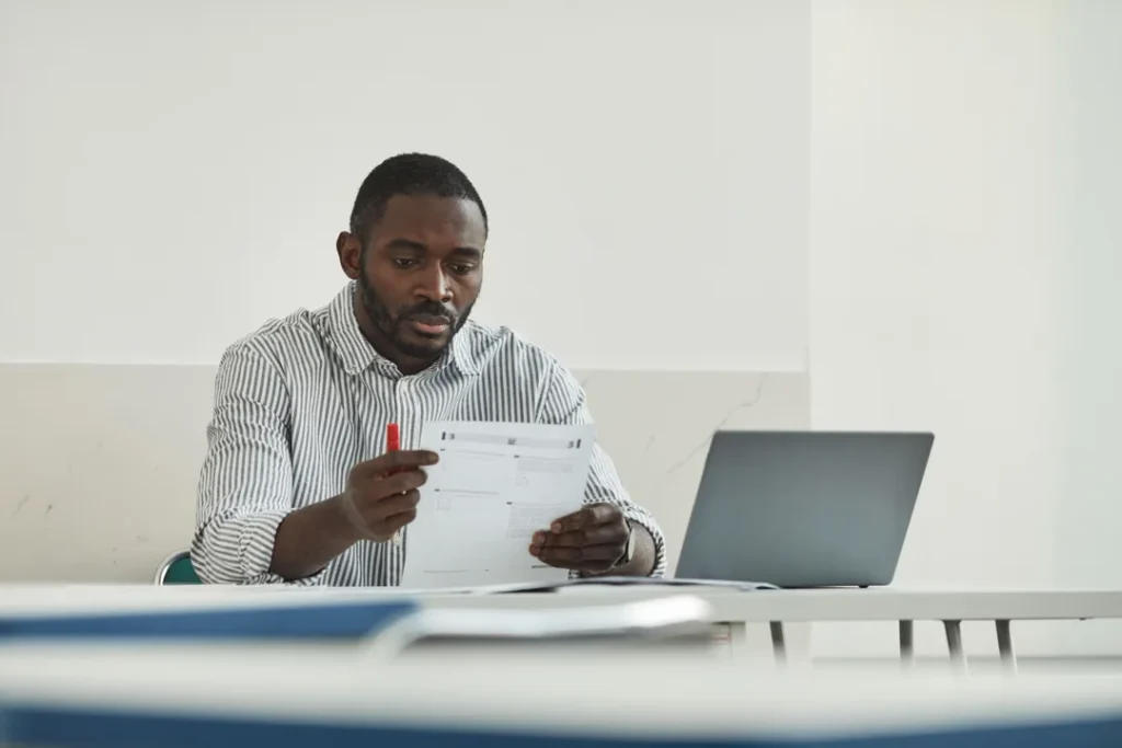 Profissional avaliando documentos de patentes e marcas em escritório moderno