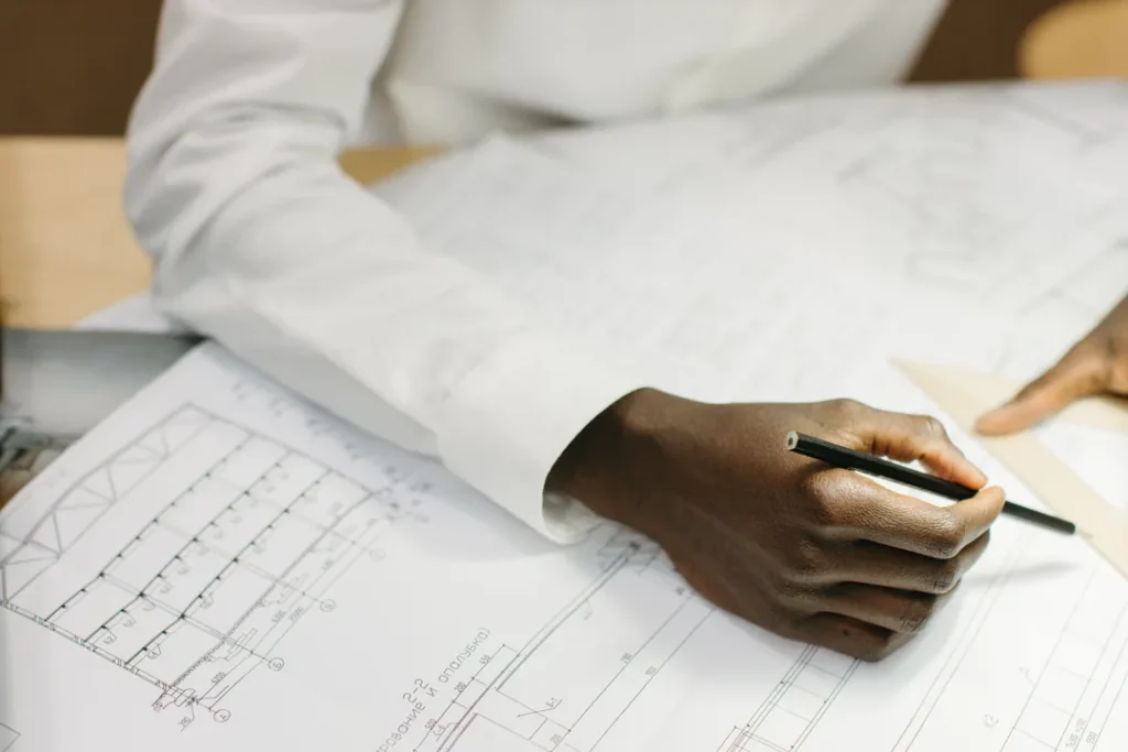 Engenheiro civil analisando projetos arquitetônicos em uma prancheta no escritório