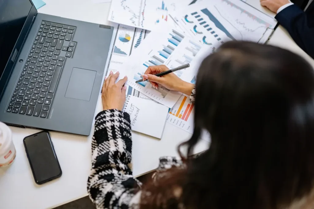 Profissional trabalhando em escritório com computador analisando documentos financeiros