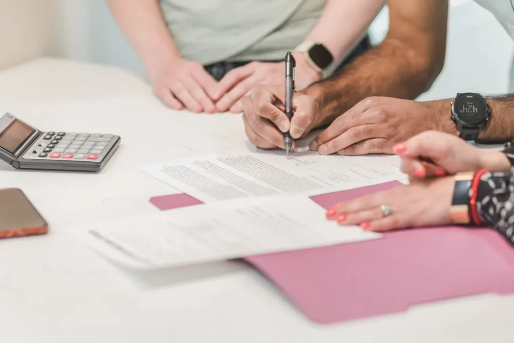 Pessoas assinando contrato de empréstimo em uma mesa de escritório