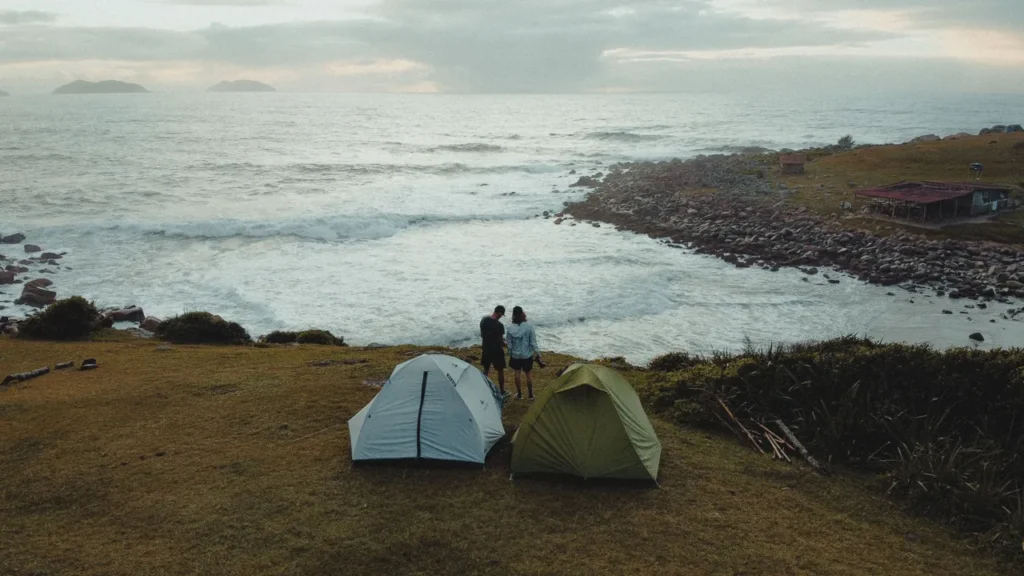 Pessoas montando barraca de camping em uma área verde ao ar livre