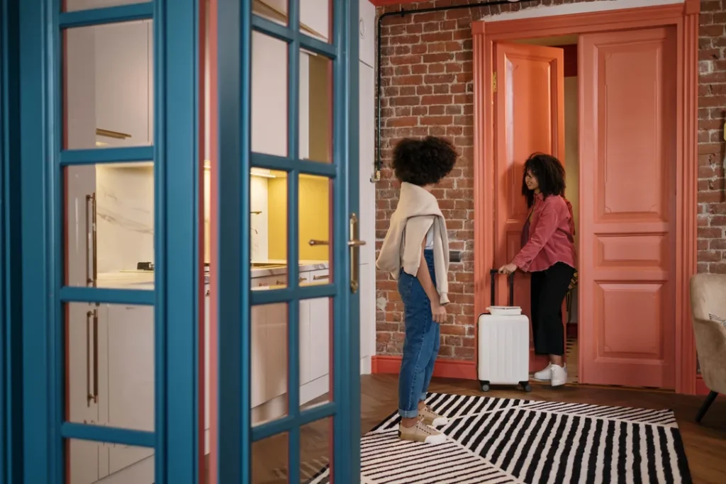Fachada de um apart-hotel moderno com pessoas chegando com malas