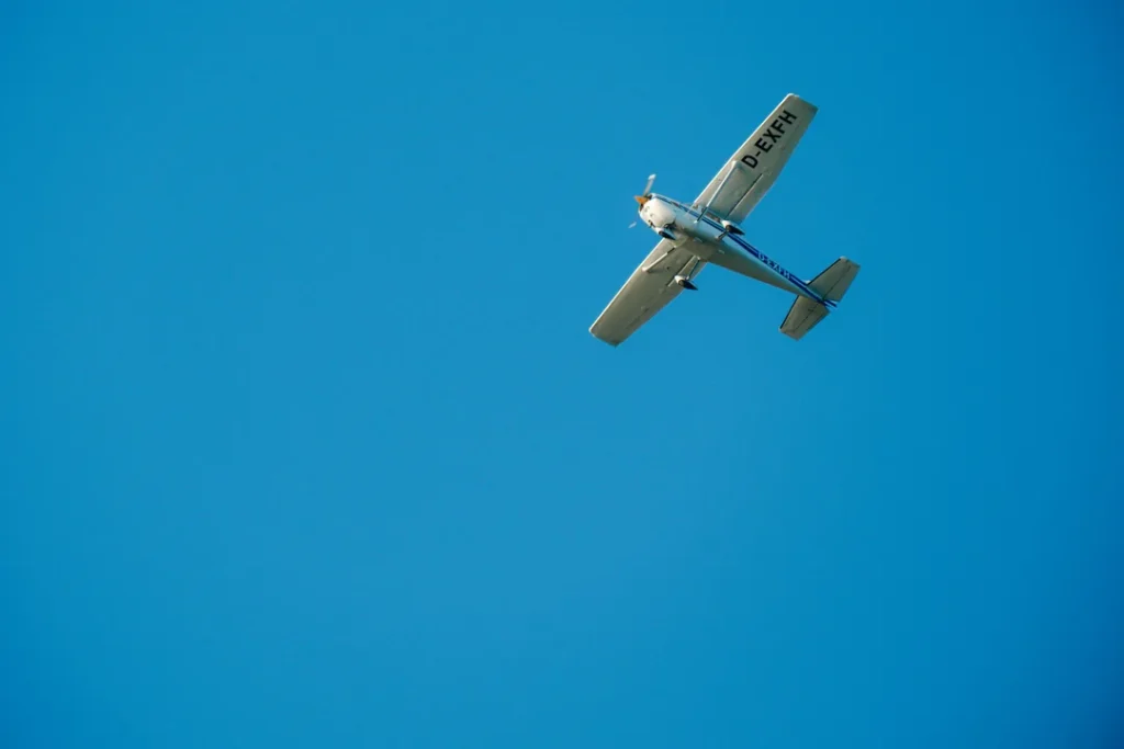 Avião particular voando no céu azul representando transporte aéreo não regular