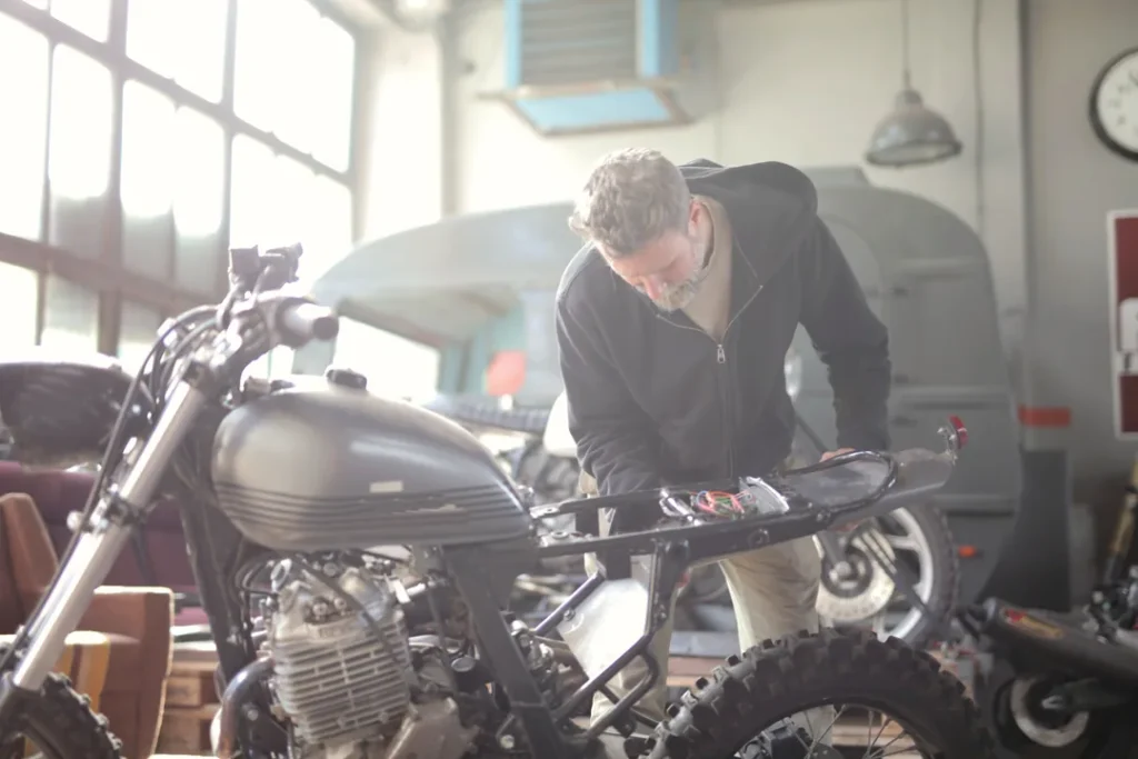 Engenheiro mecânico inspecionando peças de motocicleta em uma fábrica