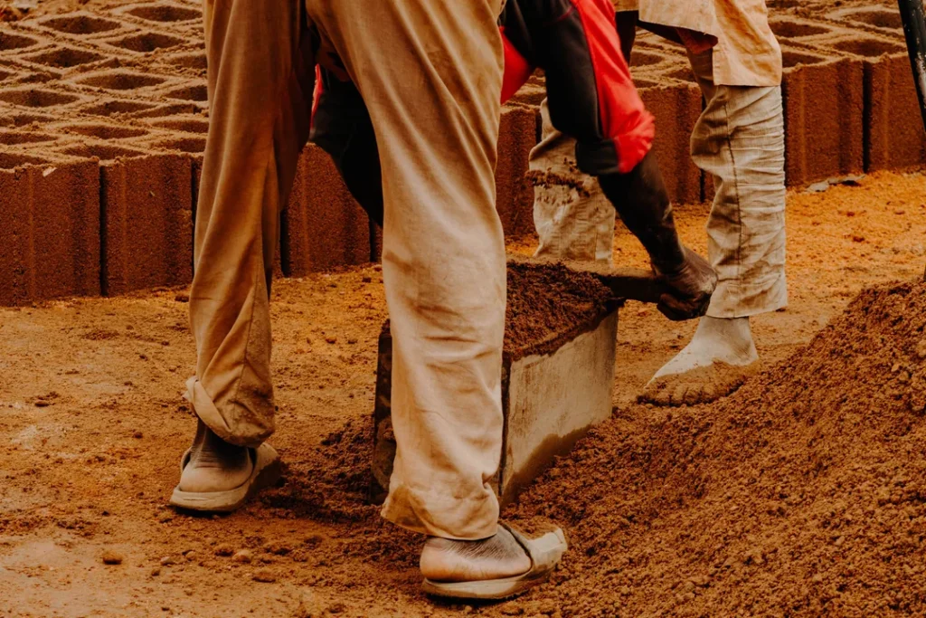 Fábrica de pré-moldados de concreto com operários trabalhando na produção de estruturas