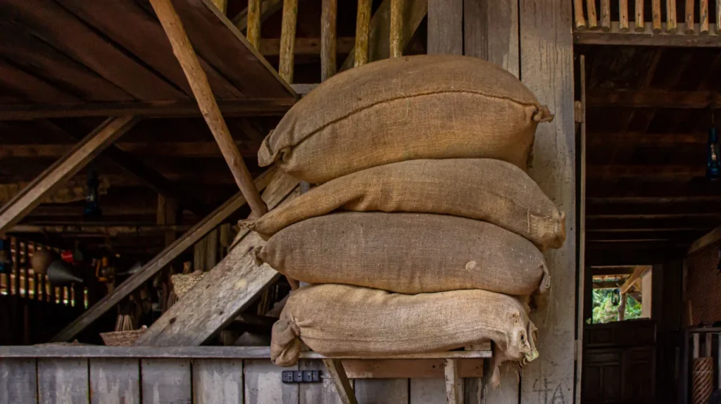 Sacos de café em grão empilhados em um armazém atacadista