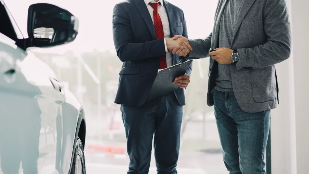 Vendedor de carros conversando com cliente em uma concessionária
