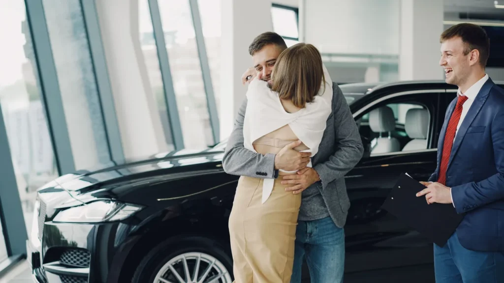 Representante comercial de carros fechando negócio com cliente em concessionária