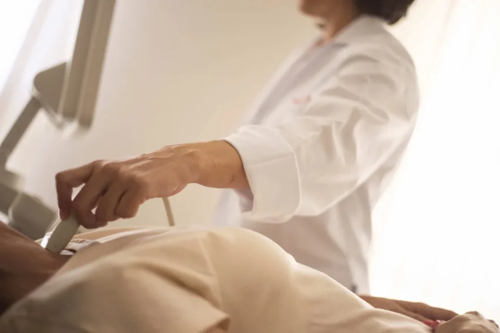 Médico realizando exame de ultrassonografia em paciente numa clínica