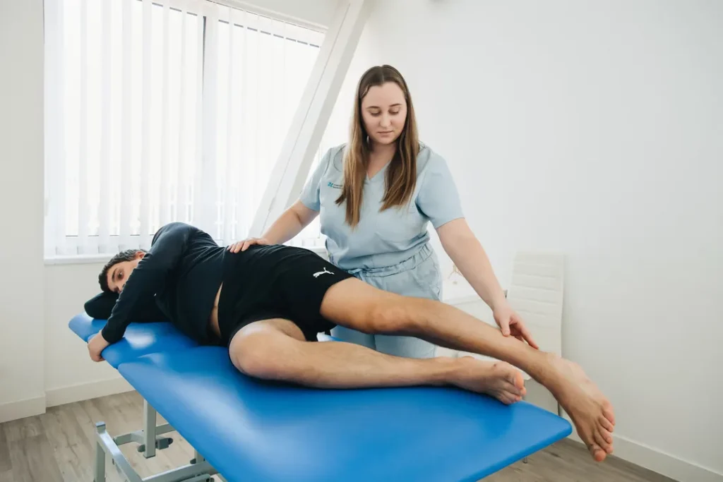 Fisioterapeuta realizando atendimento de reabilitação em paciente em uma clínica