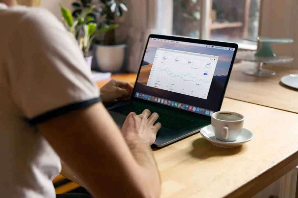 Pessoa usando notebook para apostas online em um ambiente moderno