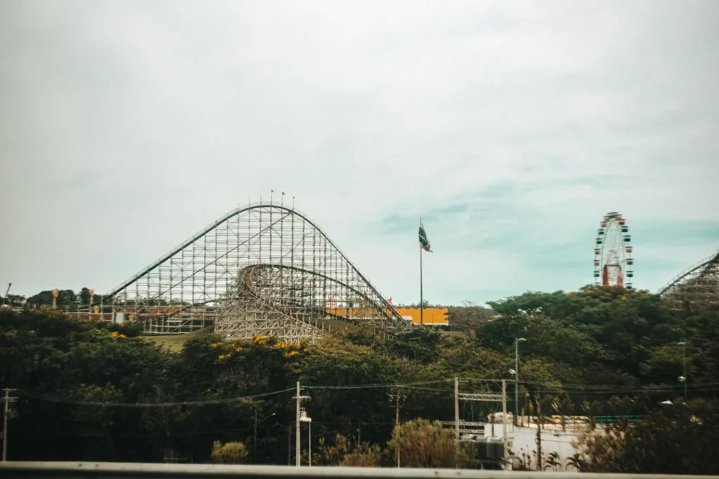 Familia se divertindo em um parque de diversoes com montanha russa ao fundo