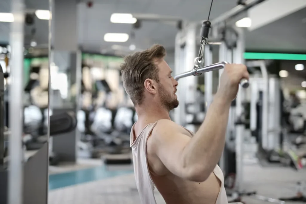 Pessoa treinando musculação em uma academia moderna com equipamentos