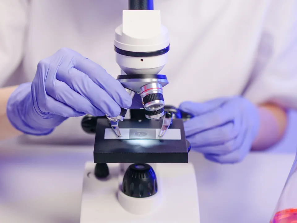 Laboratorio de pesquisa medica com cientista analisando amostras biologicas em microscopio