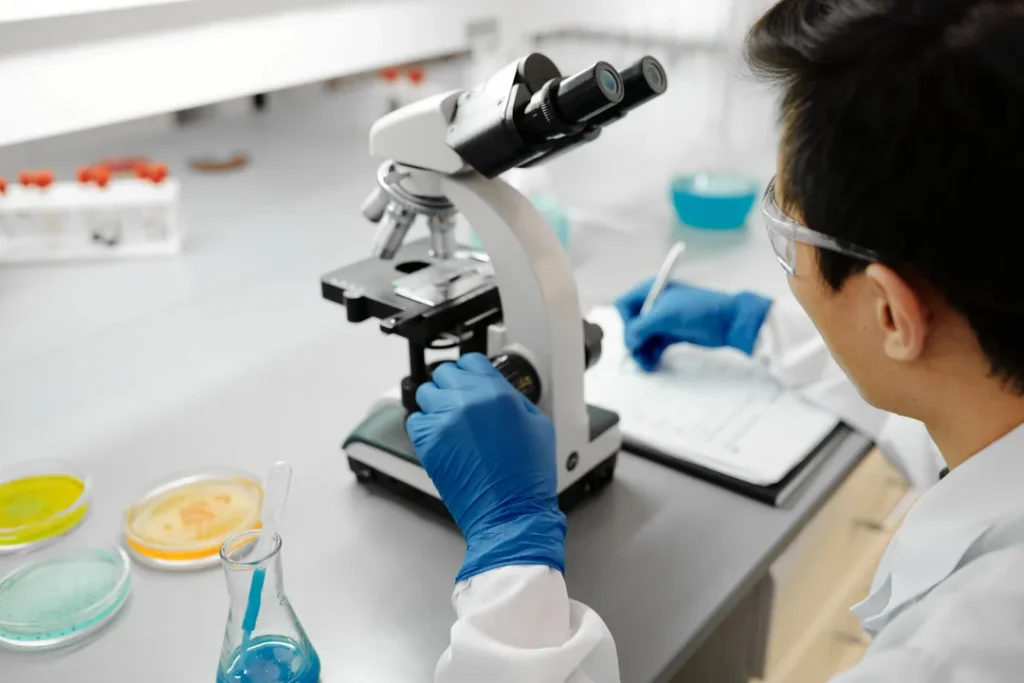 Tecnico de laboratorio realizando exame em microscopio