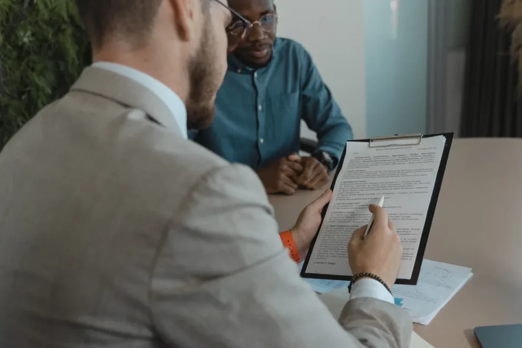 Gestor de recursos humanos analisando currículos e documentos em um escritório corporativo