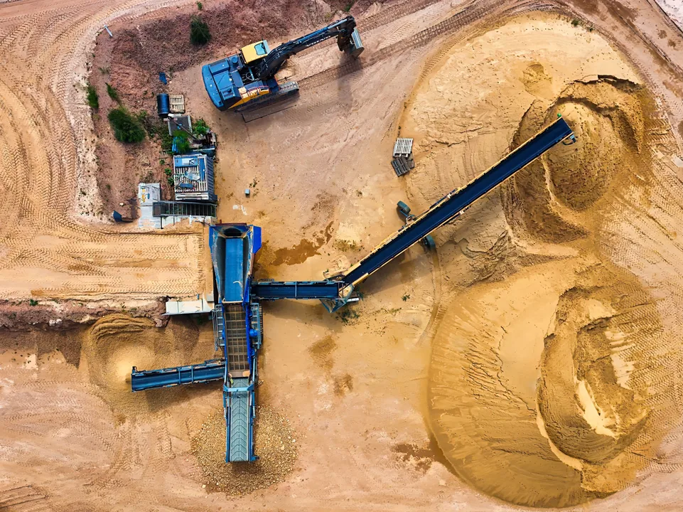 Trabalhador inspecionando equipamentos pesados de mineração em uma pedreira