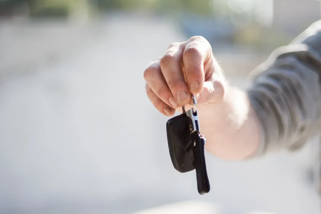 Pessoa pegando a chave de um carro alugado em uma locadora
