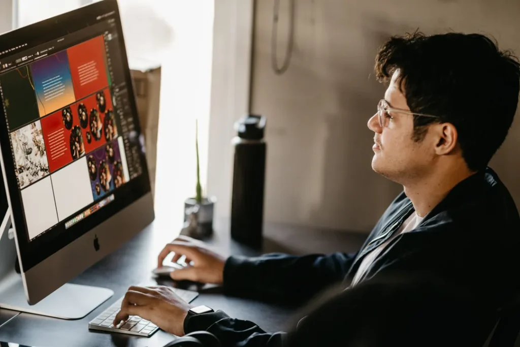 Designer gráfico trabalhando no computador com projetos visuais em um escritório moderno