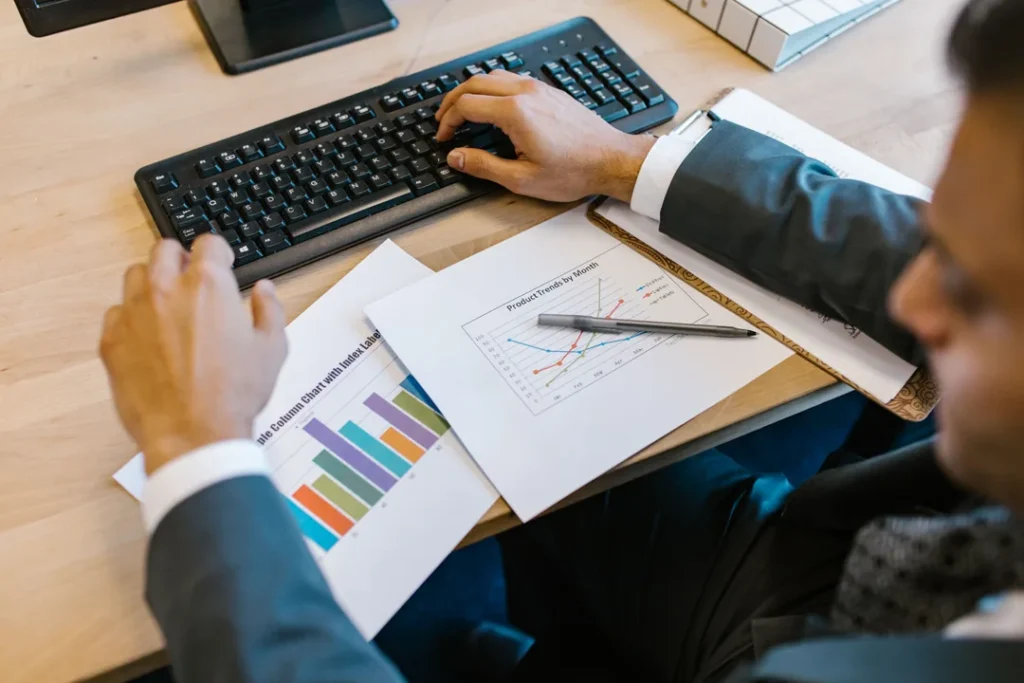 Profissional analisando dados estatísticos e gráficos de pesquisa de mercado em escritório