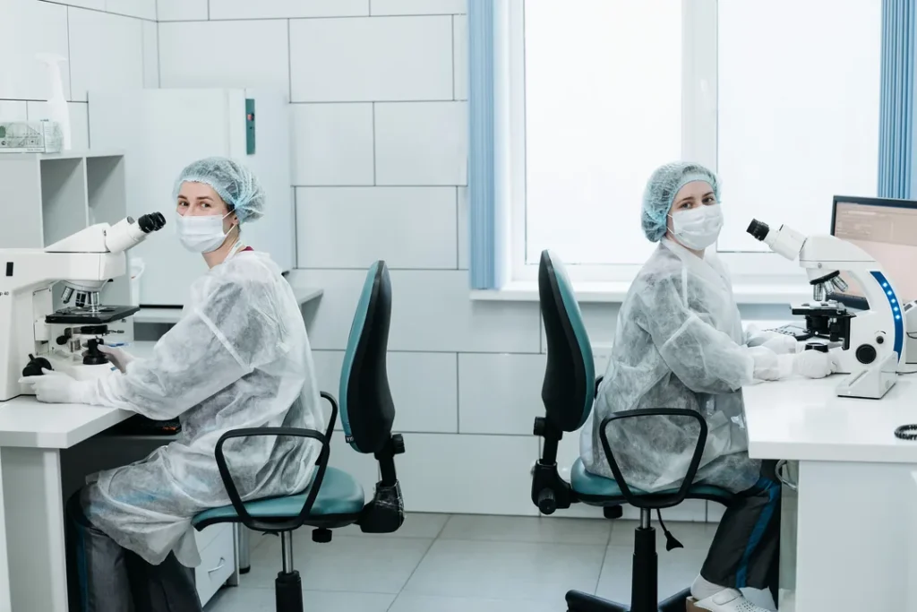 Pesquisadores trabalhando com microscópio em um laboratório moderno de ciências