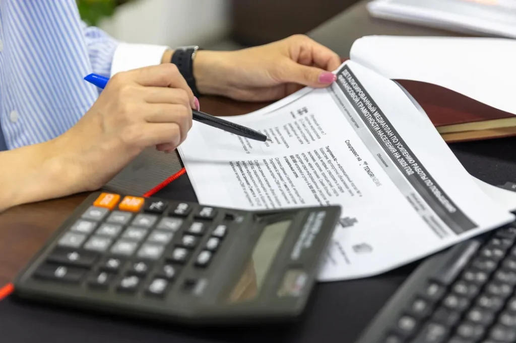 Contador analisando documentos financeiros e planilhas em um escritório moderno