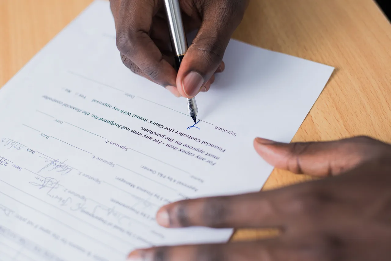Mão assinando um contrato