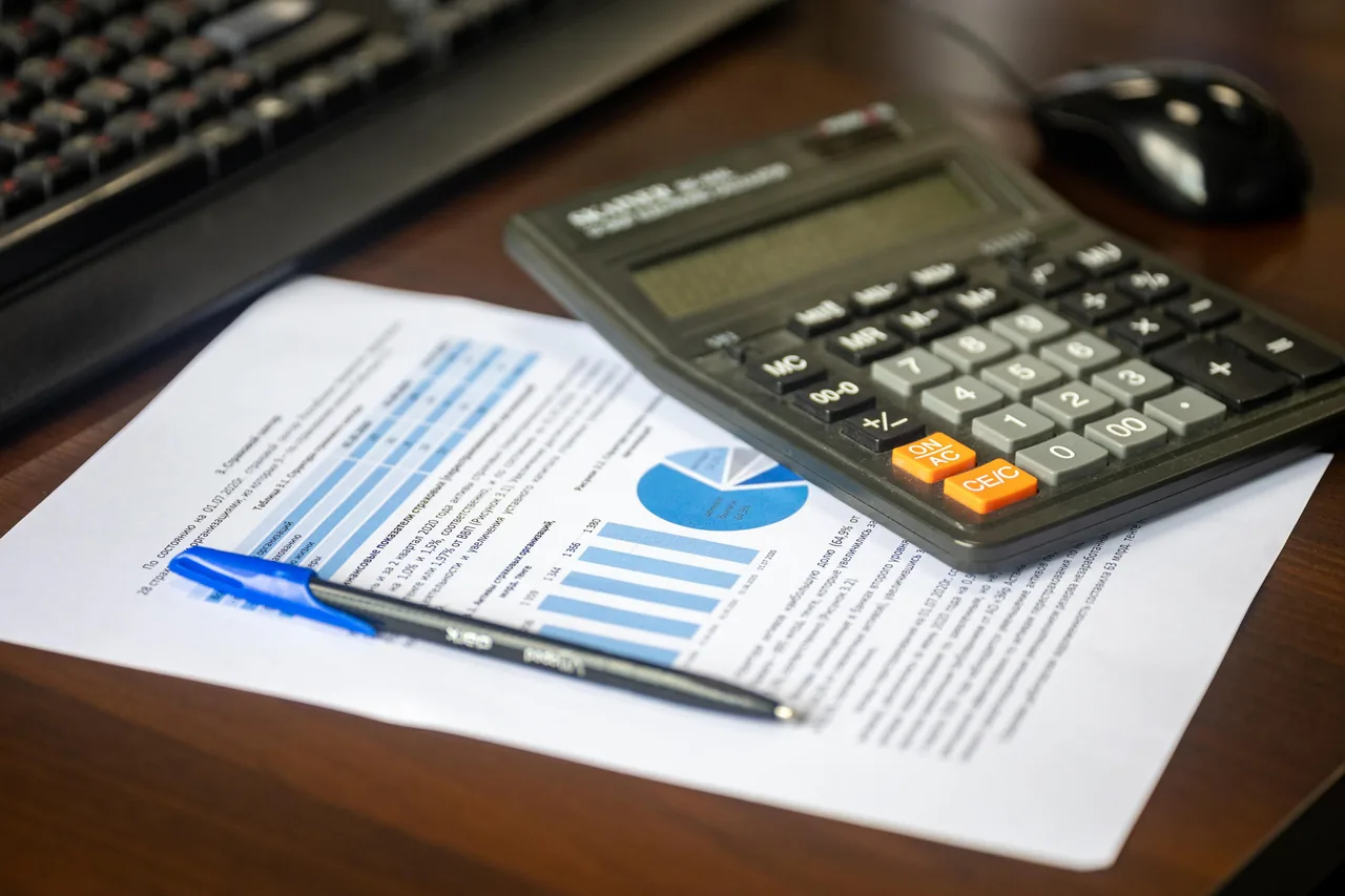Calculadora e relatório financeiro sobre a mesa